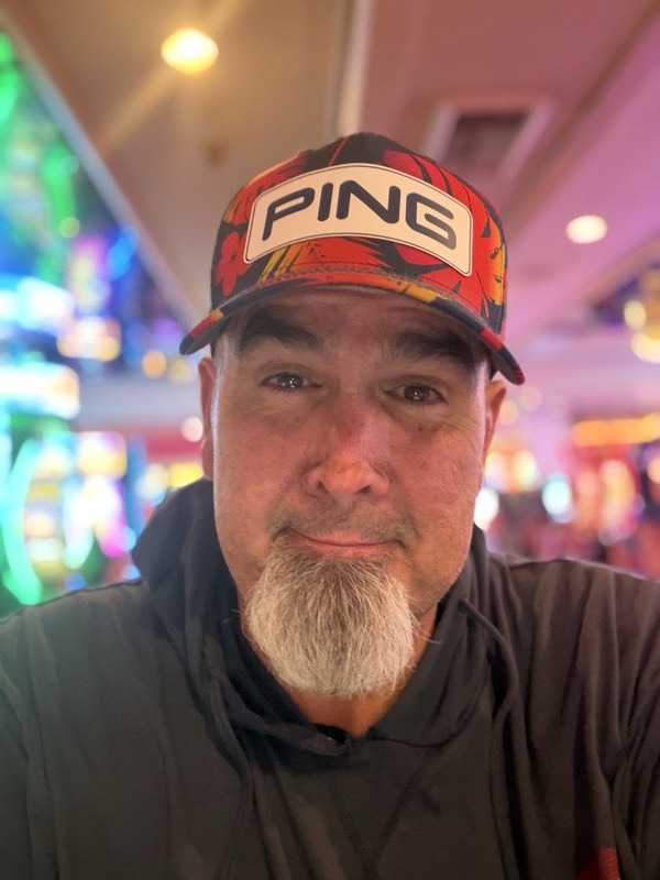A selfie inside a casino under saturated neon lighting.
